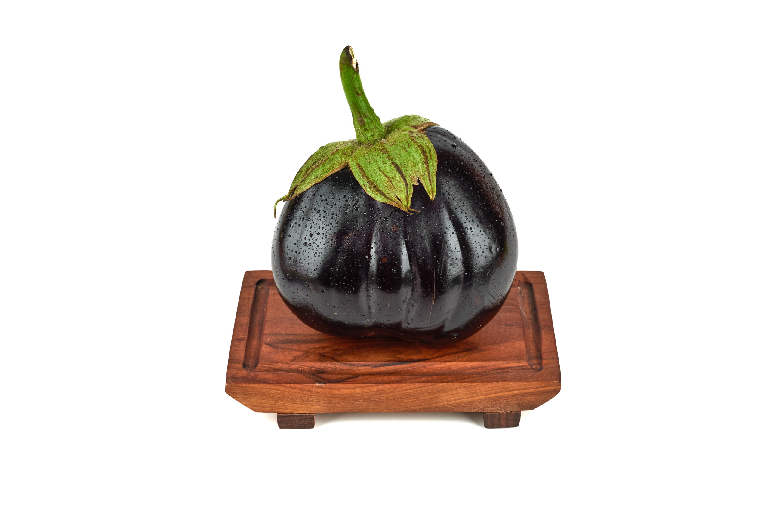 Single eggplant on a wooden platter