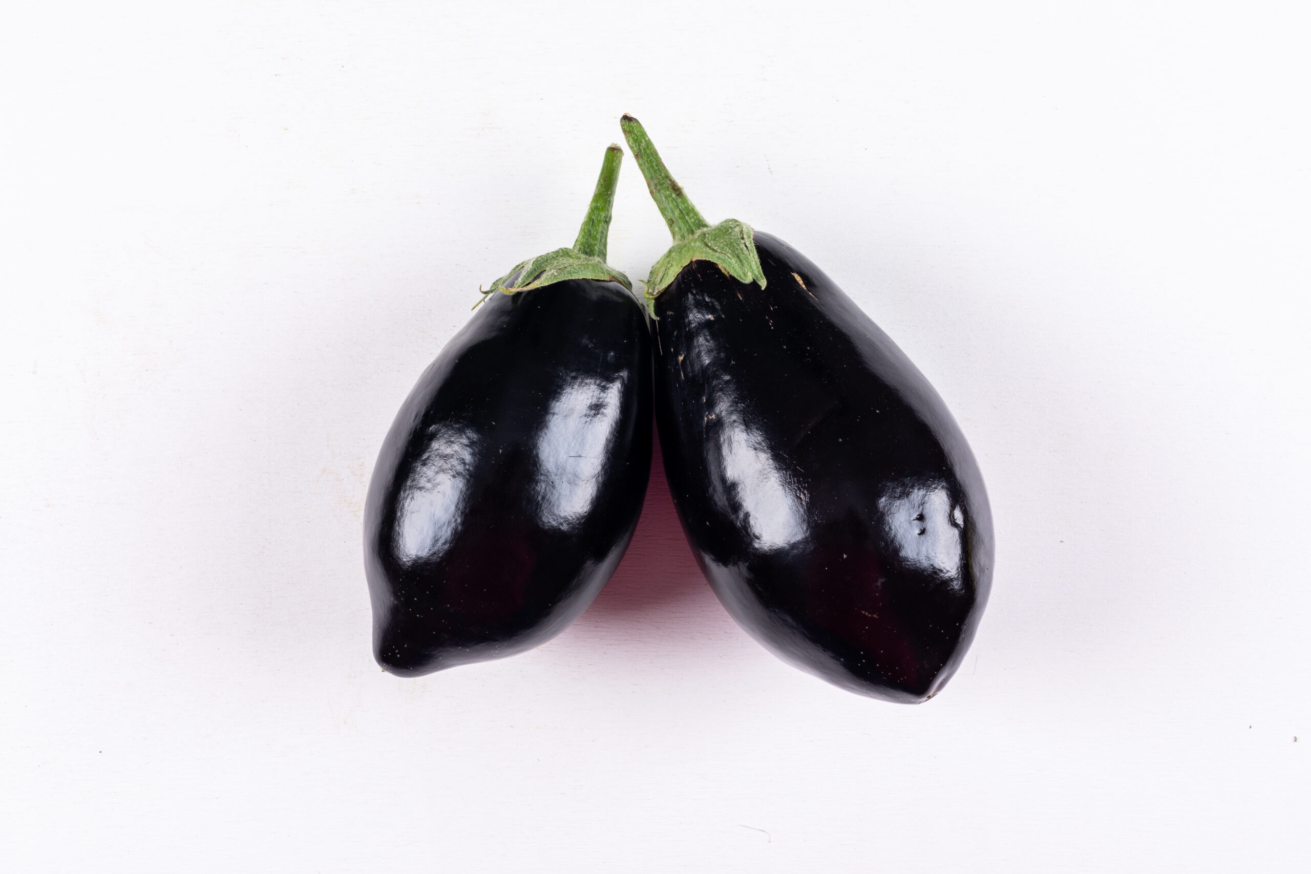 Eggplants side by side on a white background. top view.